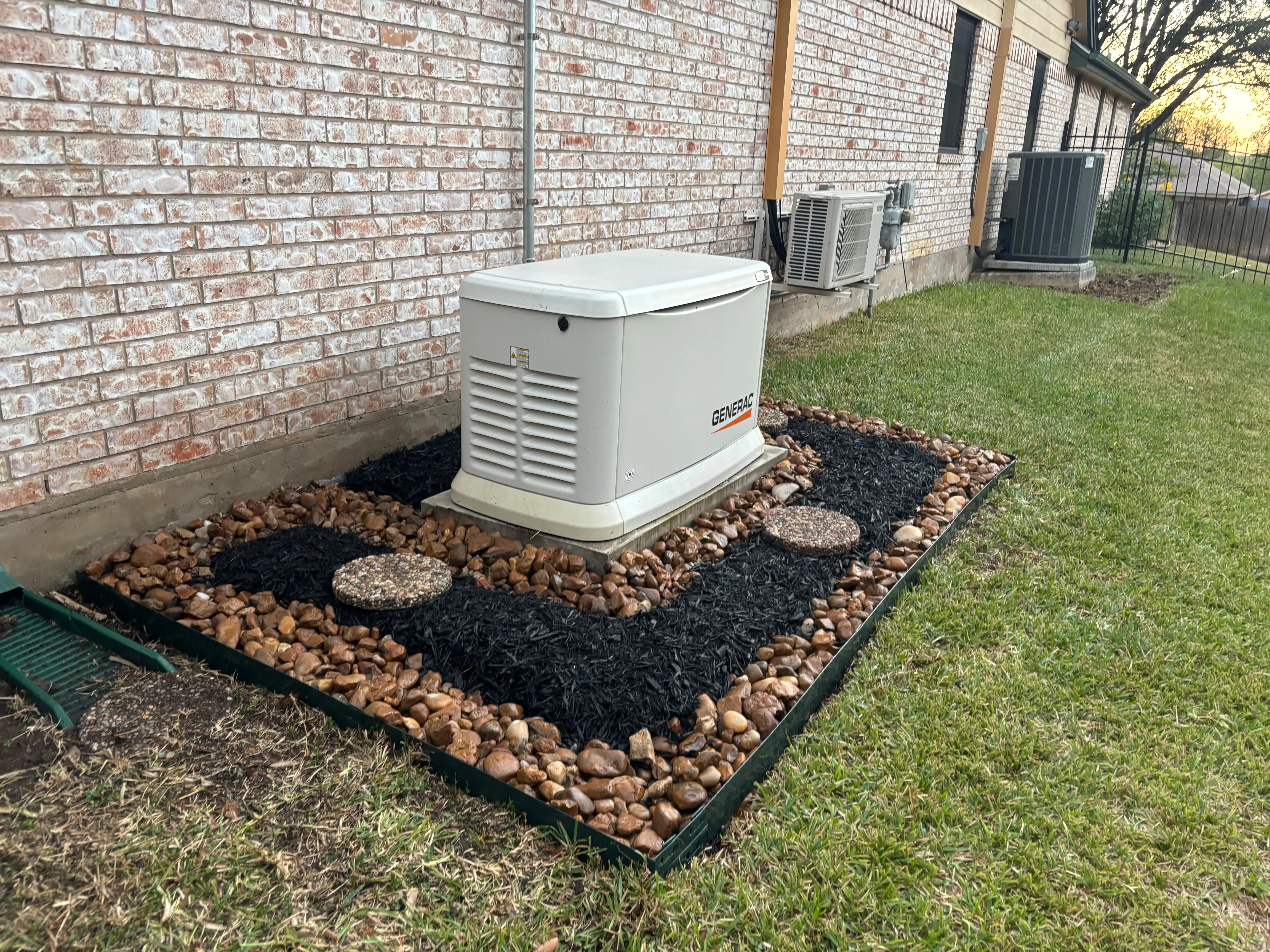 Mulch and rock decoration besides a generator.
