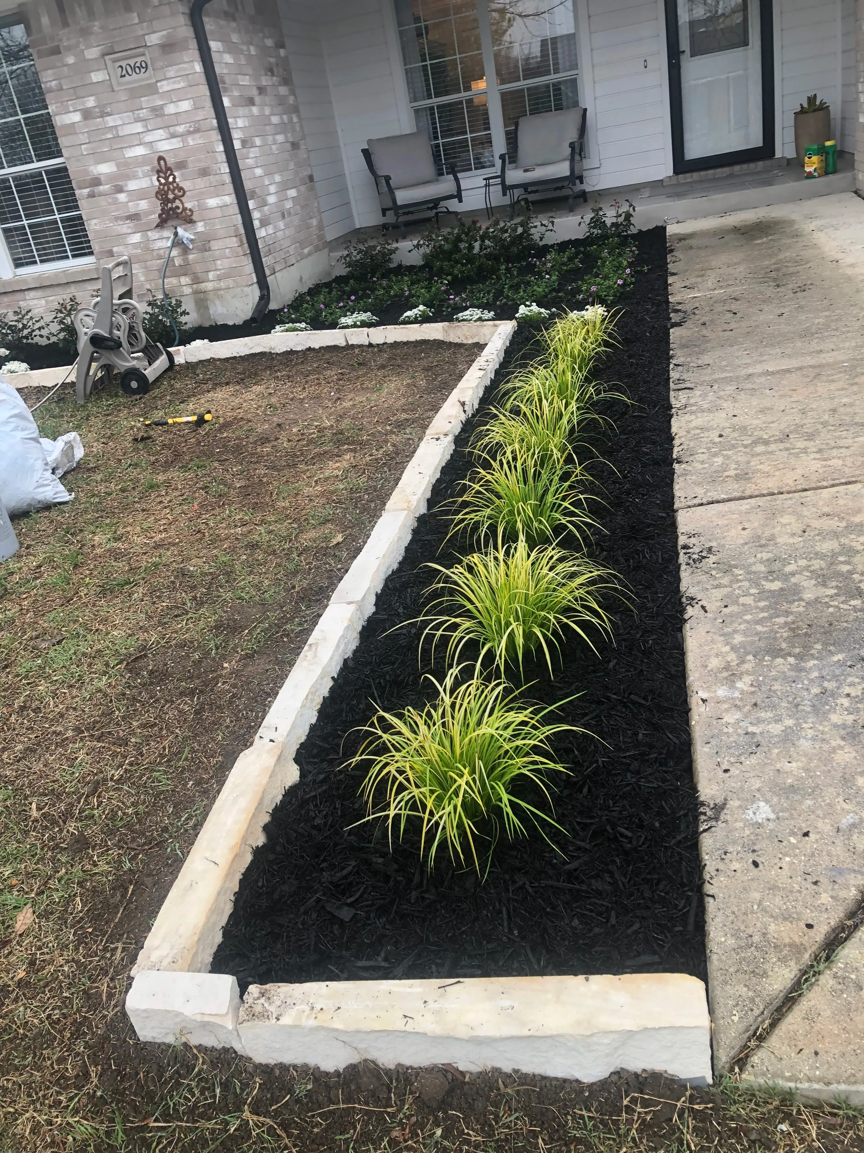 Mulch bed landscaping in front of a house.